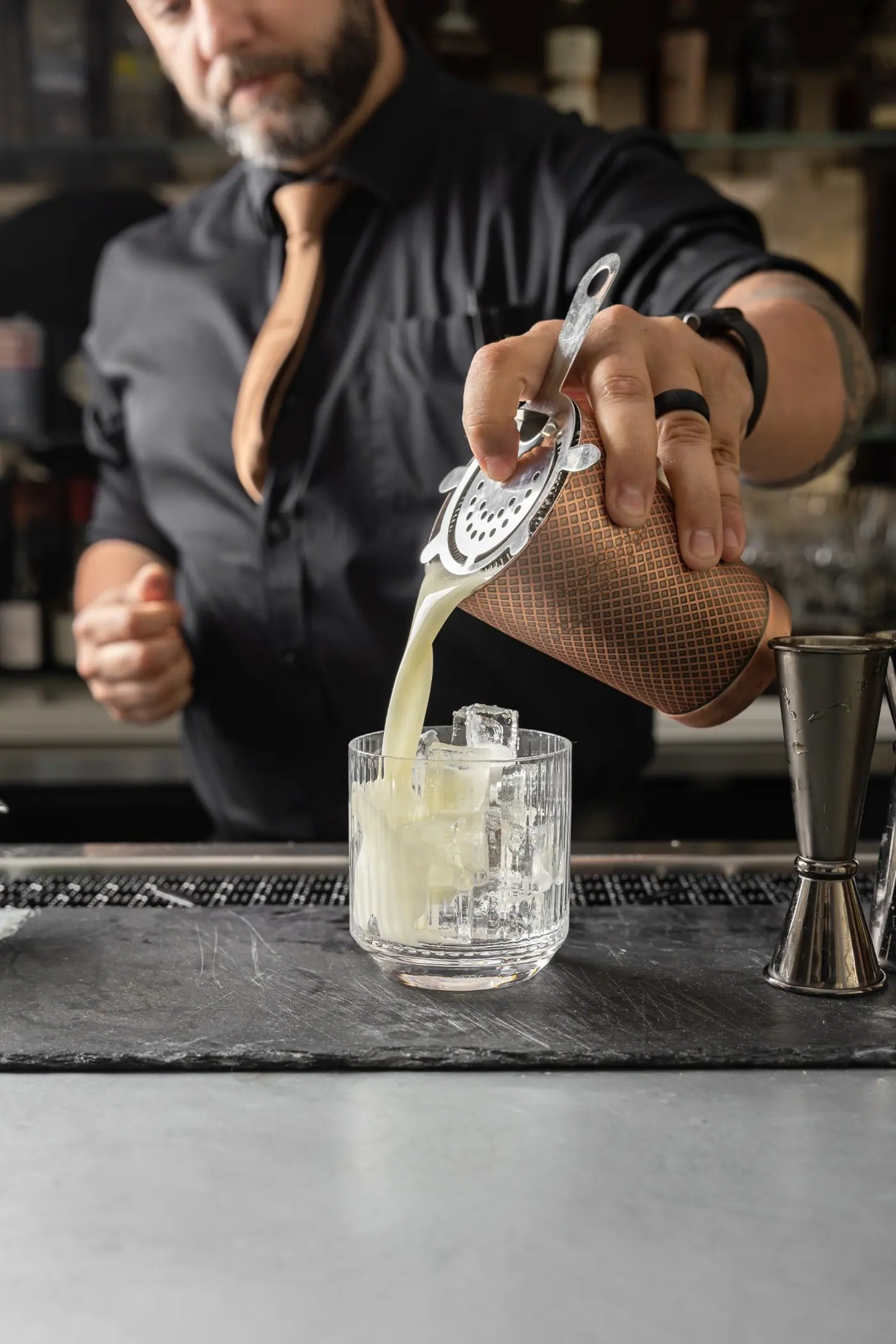 A cocktail being poured at the bar