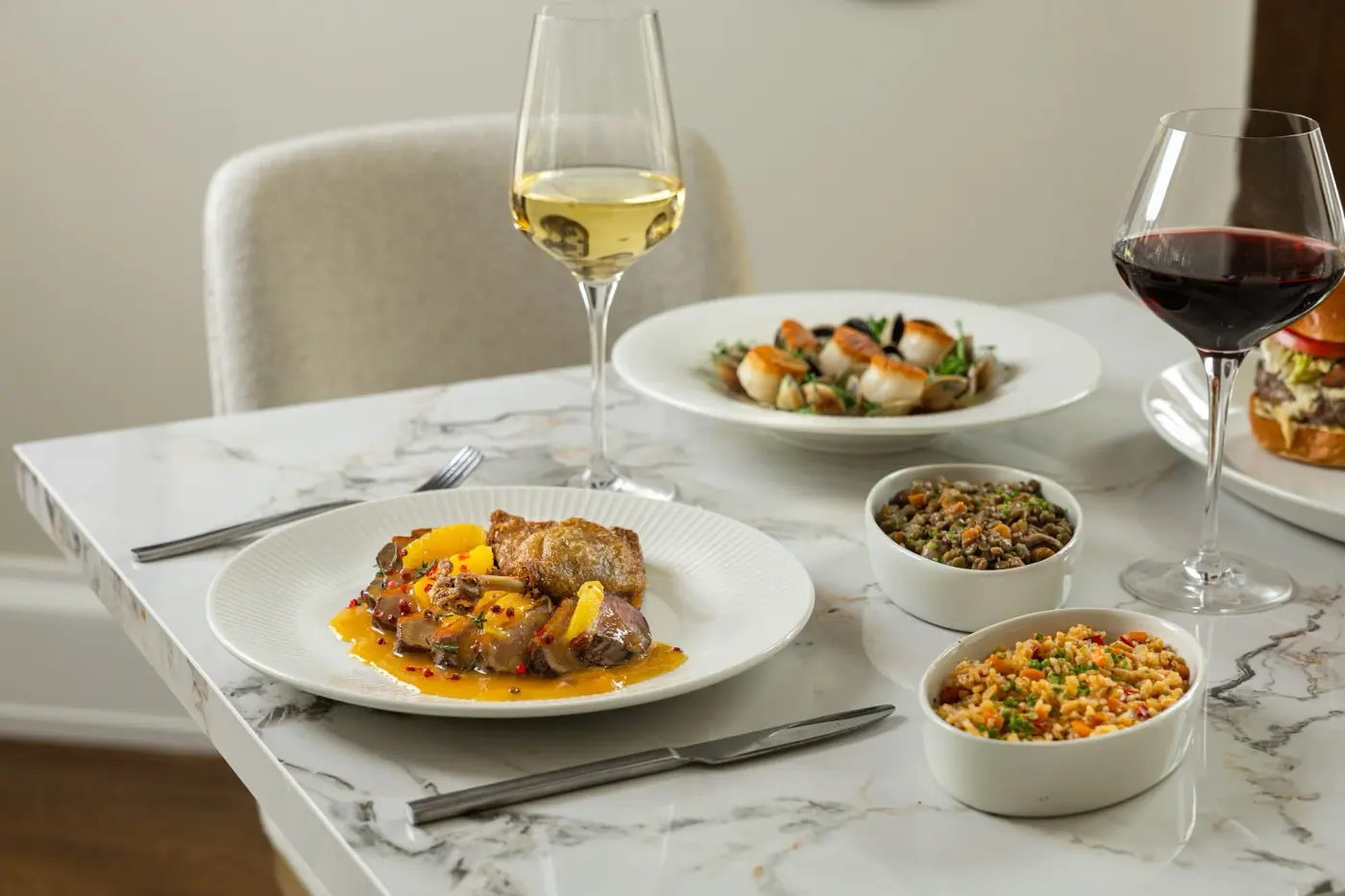 A marble table set with plates and wine